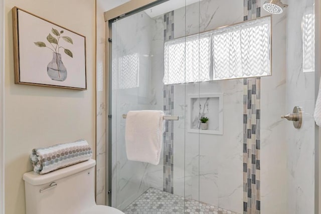 bathroom featuring walk in shower and toilet