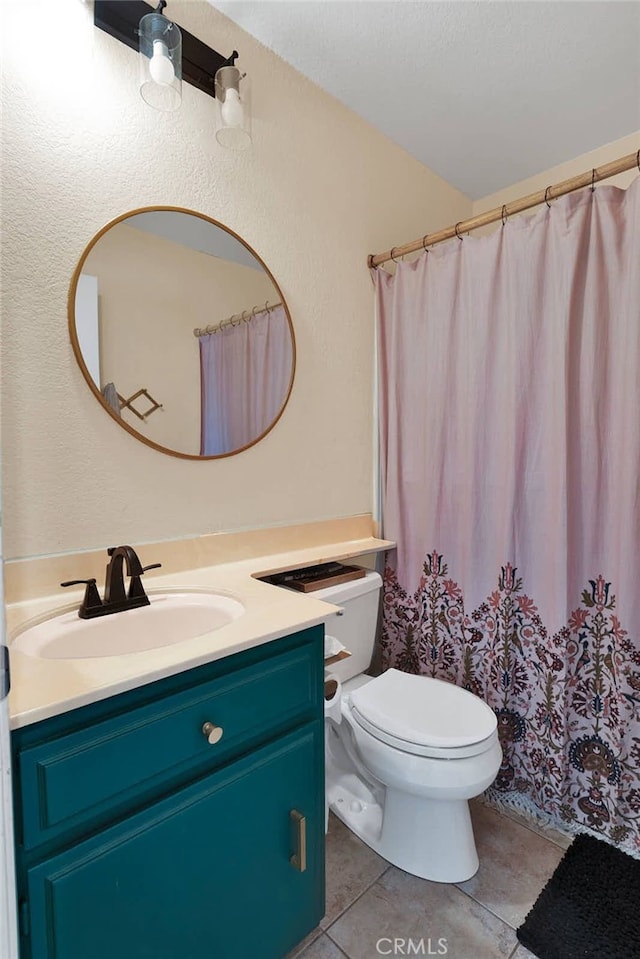 bathroom featuring tile patterned flooring, vanity, and toilet