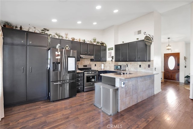 kitchen featuring pendant lighting, sink, stainless steel appliances, dark hardwood / wood-style flooring, and decorative backsplash