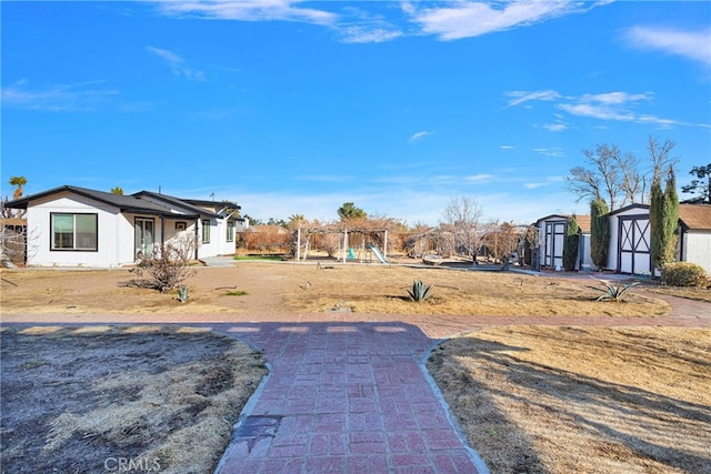 view of yard with a playground and a shed