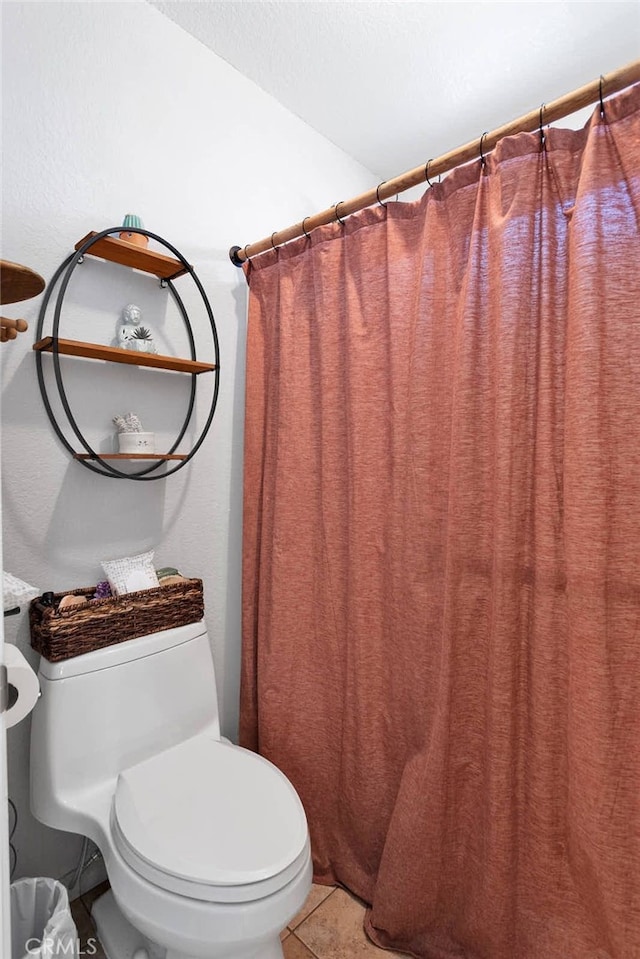 bathroom with walk in shower, tile patterned floors, and toilet