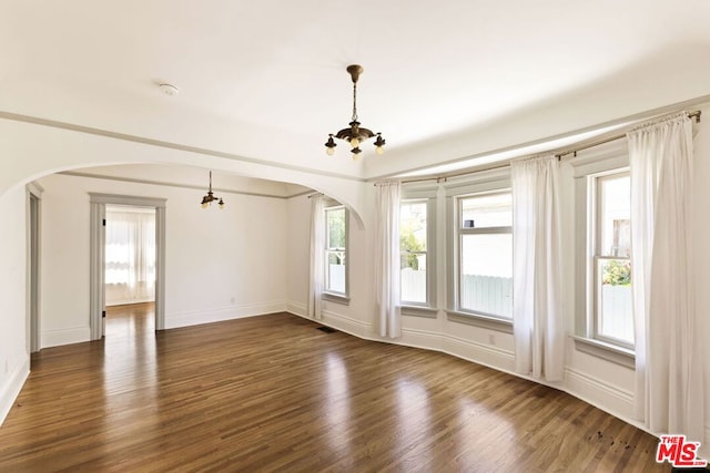 unfurnished room with dark hardwood / wood-style flooring and a chandelier