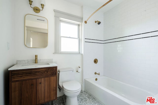 full bathroom featuring vanity, tiled shower / bath, and toilet