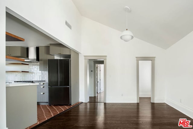 kitchen with black refrigerator, dark hardwood / wood-style floors, gray cabinets, and backsplash