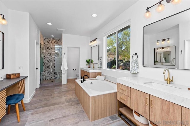 full bathroom with vanity, separate shower and tub, wood-type flooring, and toilet