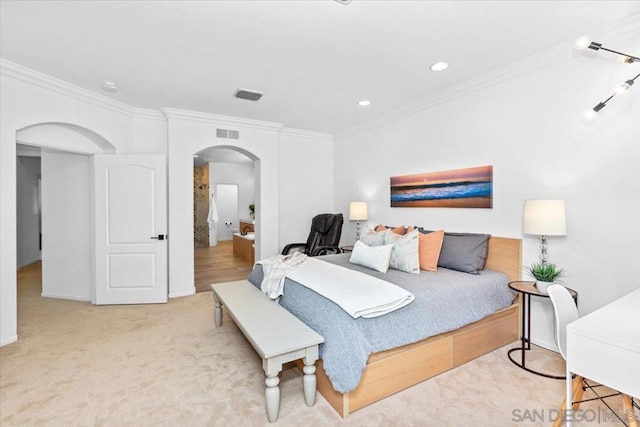 bedroom with ornamental molding and light carpet