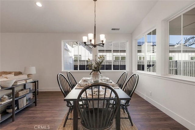 dining space with a chandelier and dark hardwood / wood-style flooring