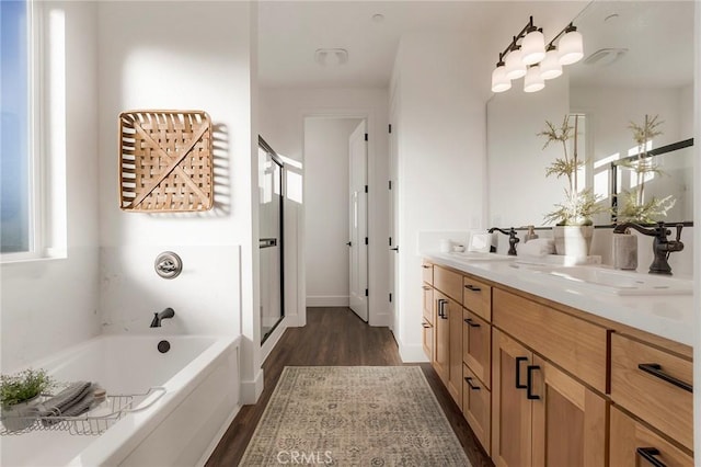 bathroom with hardwood / wood-style floors, vanity, and a washtub