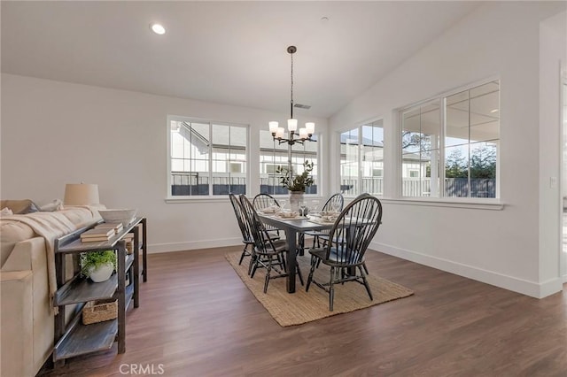 dining space featuring an inviting chandelier, dark wood-type flooring, and vaulted ceiling