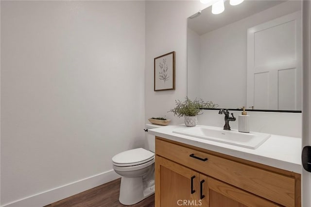 bathroom with vanity, toilet, and hardwood / wood-style floors