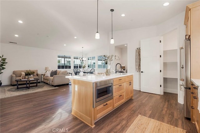 kitchen with sink, appliances with stainless steel finishes, dark hardwood / wood-style floors, an island with sink, and light brown cabinets