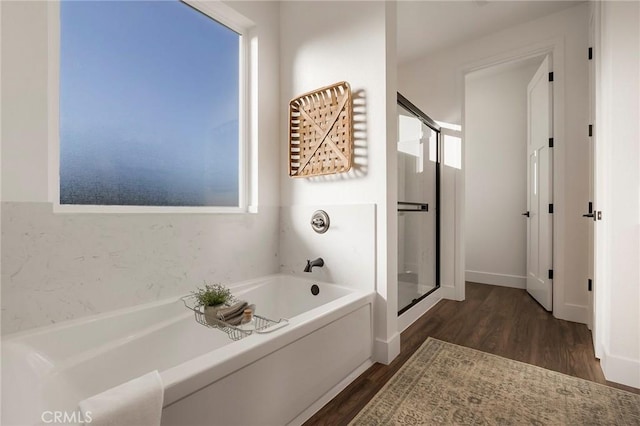 bathroom featuring wood-type flooring and independent shower and bath