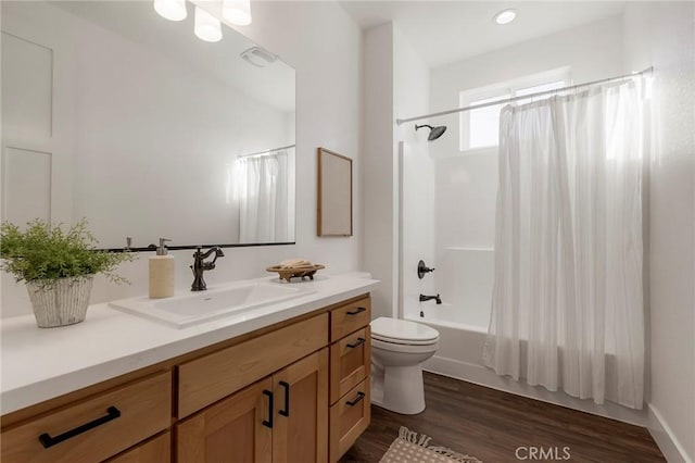 full bathroom featuring hardwood / wood-style flooring, shower / bath combo, vanity, and toilet