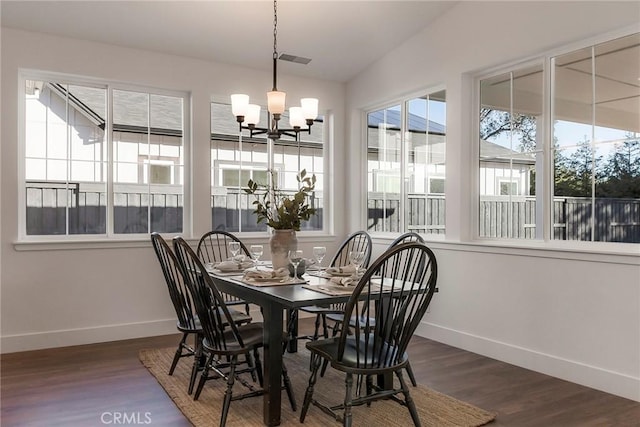 dining room with lofted ceiling, dark hardwood / wood-style floors, and an inviting chandelier