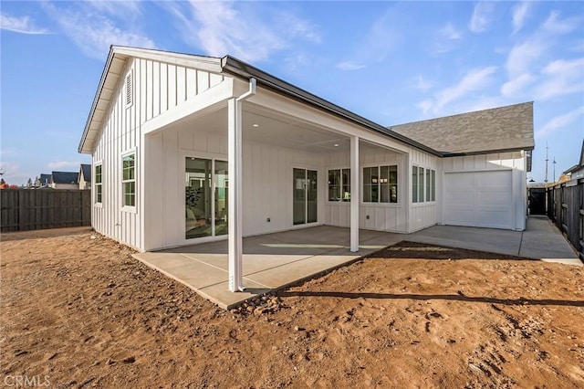 back of house with a garage and a patio