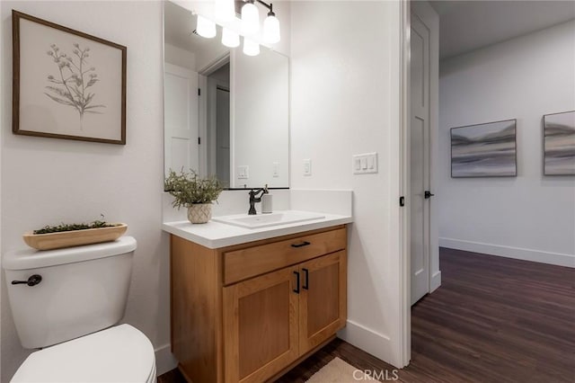 bathroom with wood-type flooring, toilet, and vanity