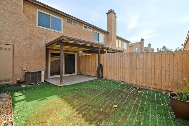 back of house featuring central AC unit, a yard, and a patio