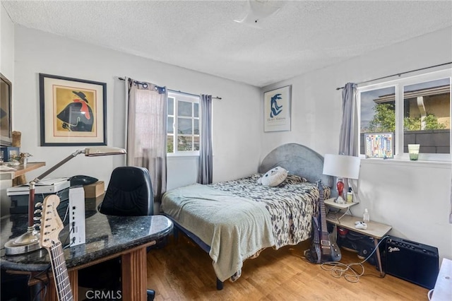 bedroom with wood-type flooring and a textured ceiling