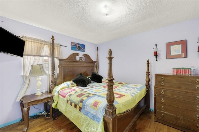 bedroom with hardwood / wood-style flooring and a textured ceiling