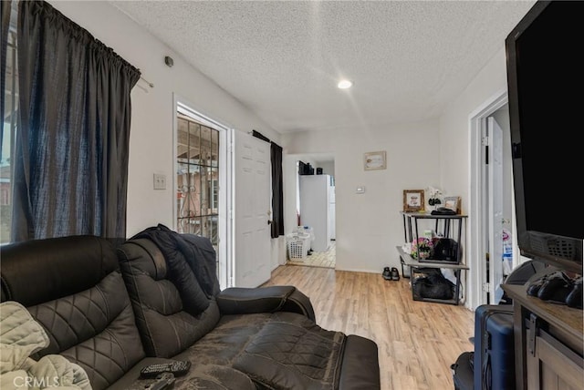 living room featuring a textured ceiling and light wood-type flooring