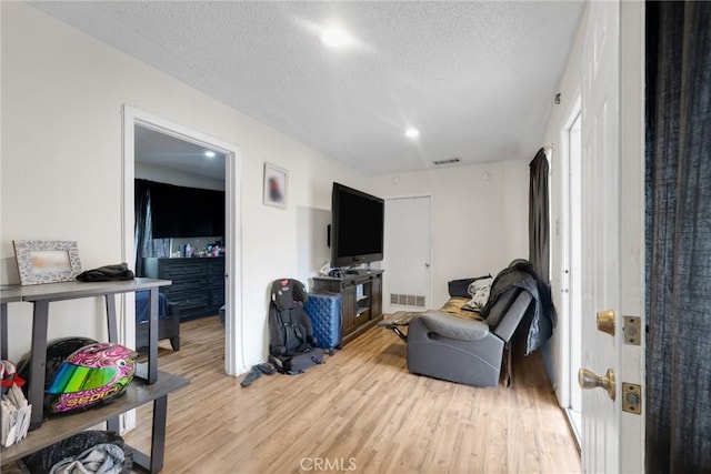 living room featuring a textured ceiling and light wood-type flooring