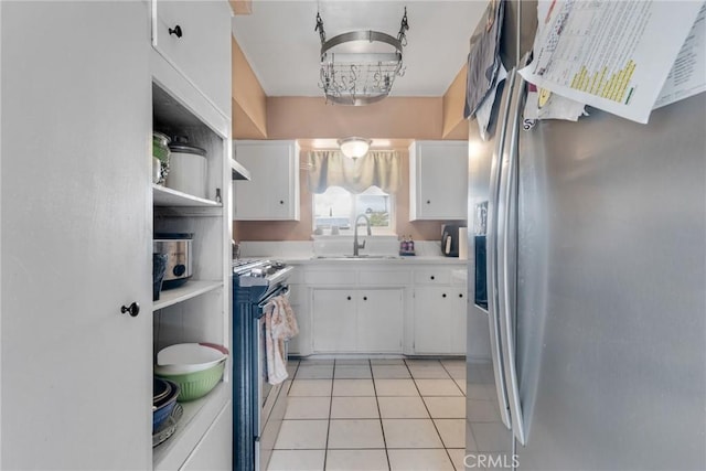 kitchen featuring sink, light tile patterned floors, white cabinets, and appliances with stainless steel finishes