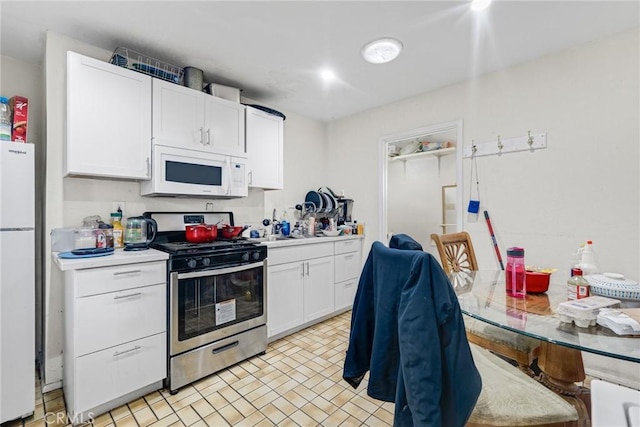 kitchen with white cabinetry and white appliances