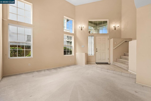 entrance foyer featuring light carpet and a high ceiling