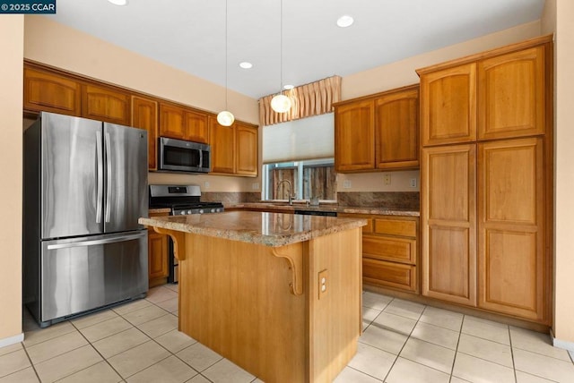 kitchen featuring light tile patterned floors, appliances with stainless steel finishes, a center island, light stone countertops, and decorative light fixtures