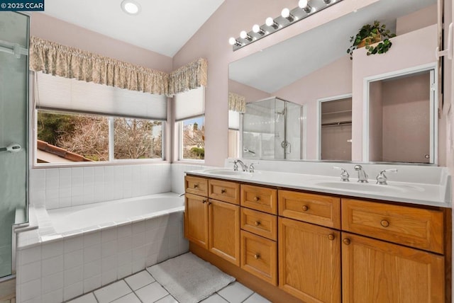 bathroom with lofted ceiling, vanity, tile patterned flooring, and plus walk in shower