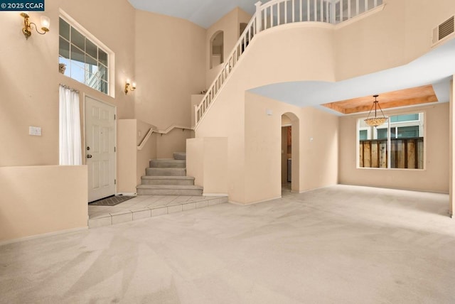 entryway featuring carpet flooring and a towering ceiling