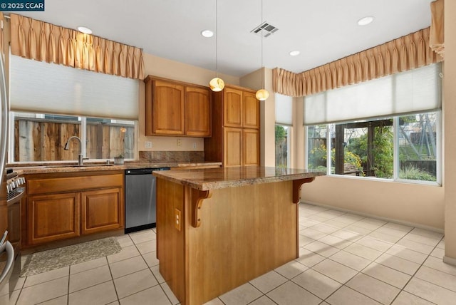 kitchen with sink, decorative light fixtures, a center island, dishwasher, and dark stone counters