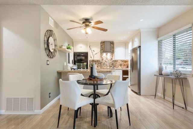 dining area with ceiling fan and light hardwood / wood-style floors