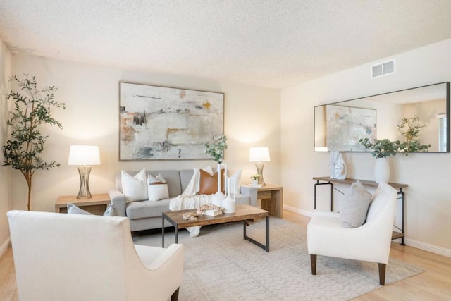 living room featuring a textured ceiling and light hardwood / wood-style floors