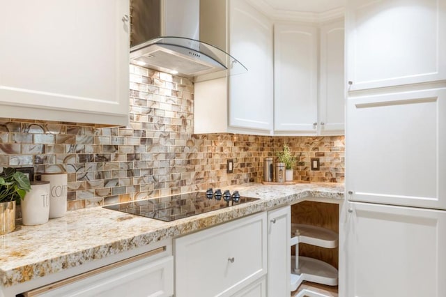 kitchen featuring black electric cooktop, island range hood, tasteful backsplash, and white cabinets