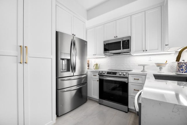 kitchen with white cabinetry, appliances with stainless steel finishes, sink, and decorative backsplash