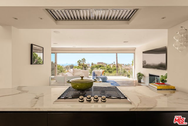 kitchen featuring light stone counters and a healthy amount of sunlight