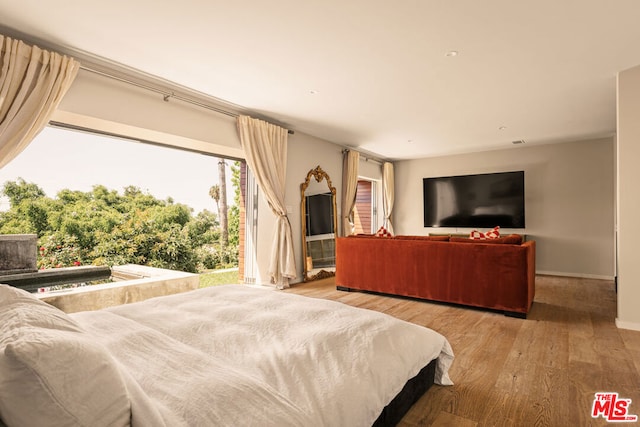 bedroom featuring access to exterior and light wood-type flooring