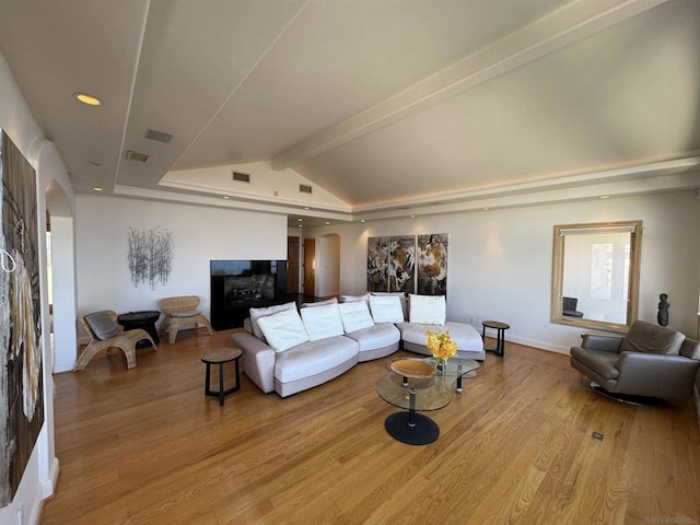 living room featuring vaulted ceiling with beams and light hardwood / wood-style floors