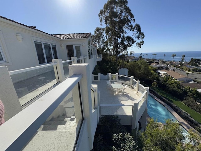 balcony featuring a water view and a patio area