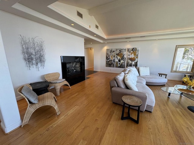 living room featuring high vaulted ceiling, beam ceiling, and light hardwood / wood-style flooring