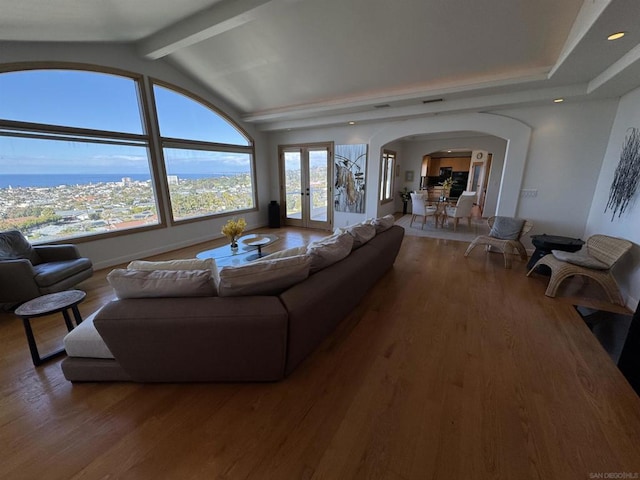 living room with french doors, hardwood / wood-style floors, and vaulted ceiling with beams