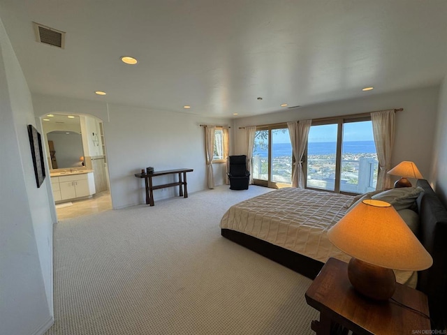 carpeted bedroom featuring ensuite bathroom and access to outside