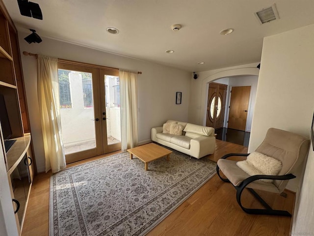 living room with french doors and light wood-type flooring