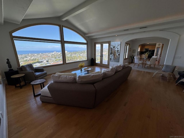 living room with vaulted ceiling with beams, hardwood / wood-style floors, and french doors