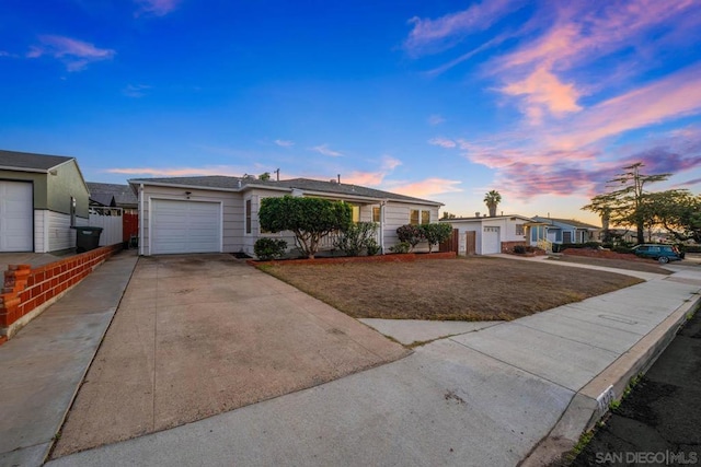 single story home featuring a garage and a yard