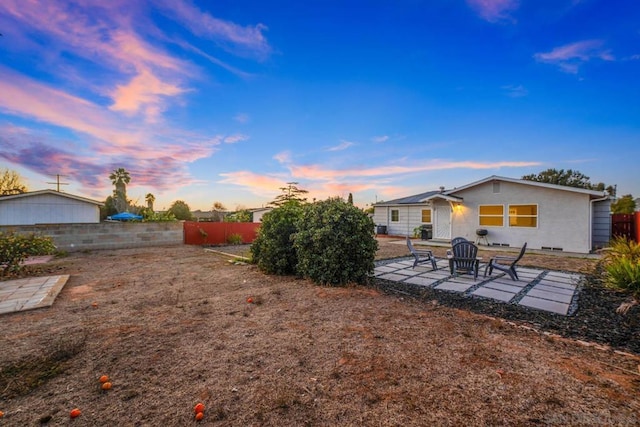 yard at dusk featuring a patio area