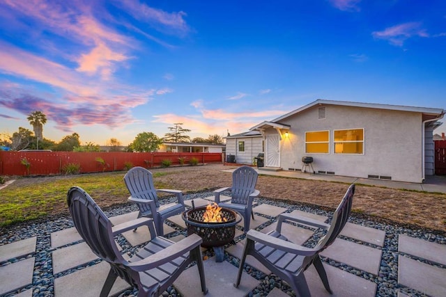 patio terrace at dusk featuring a fire pit