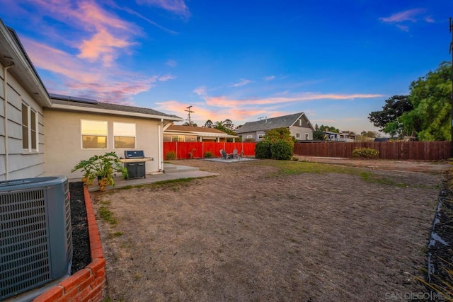 yard at dusk with a patio and central air condition unit