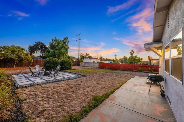 yard at dusk with a patio and an outdoor fire pit